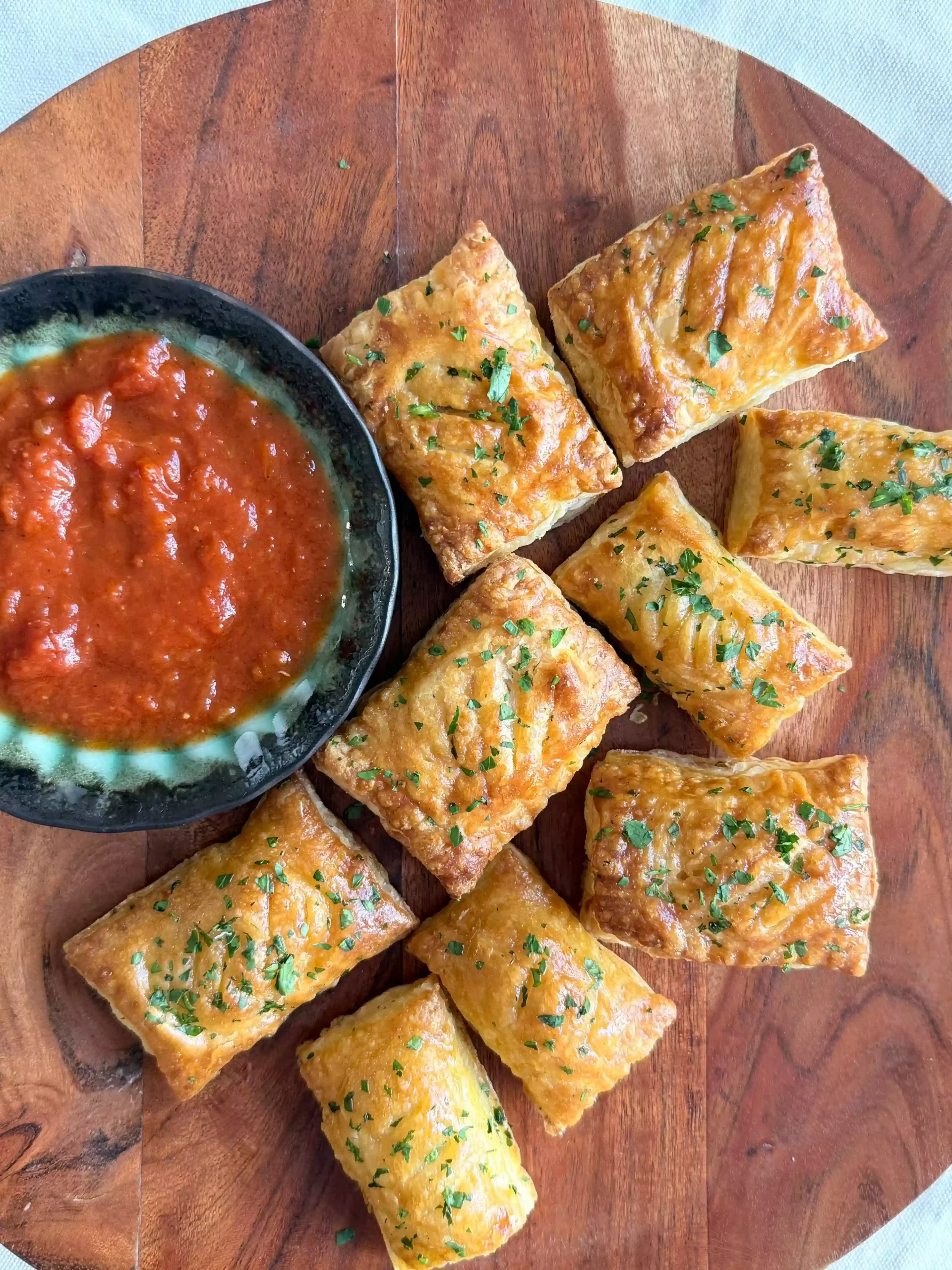 Golden puff pastry pockets filled with mozzarella and prosciutto for a party appetizer.